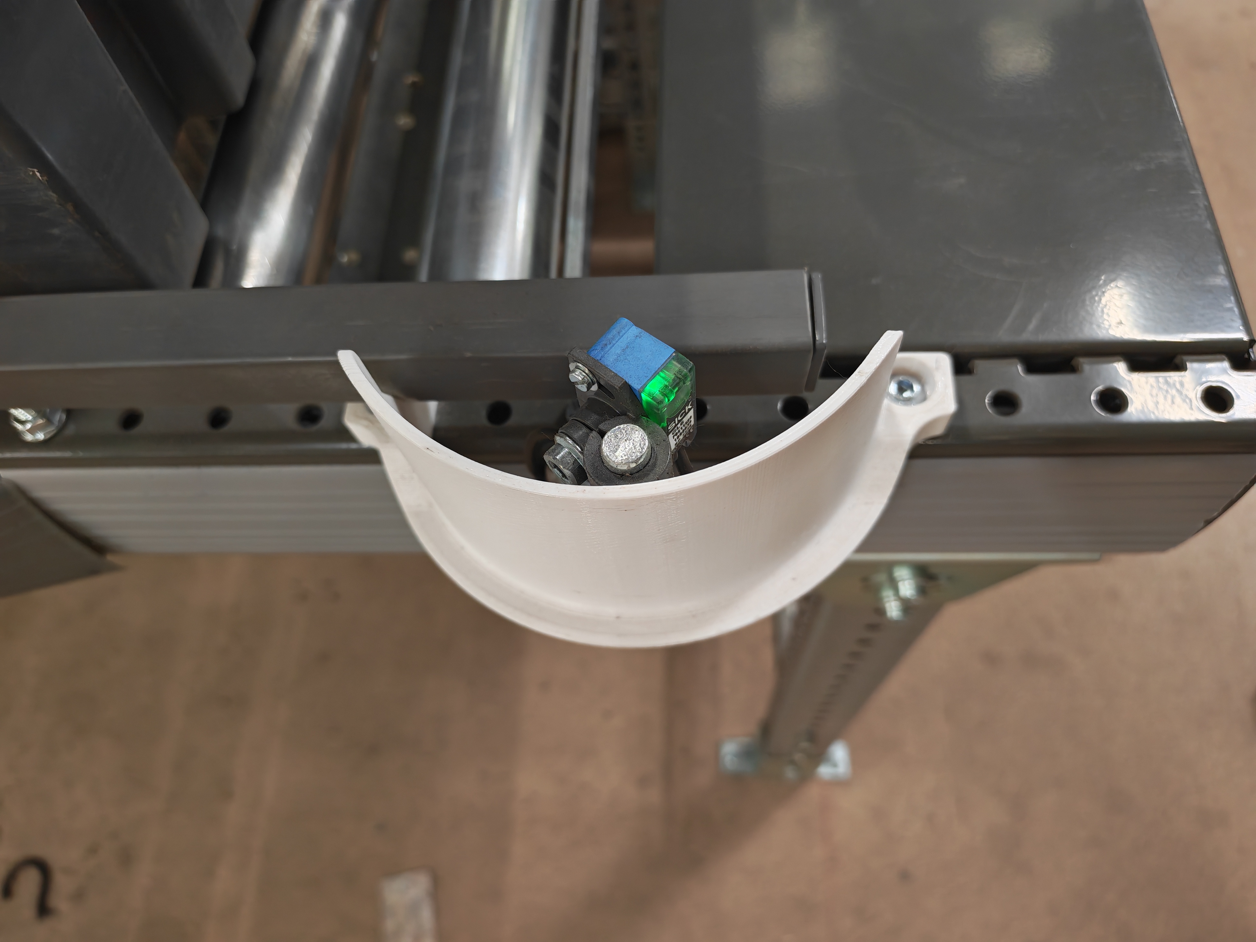 Sensor guard underside view installed on conveyor